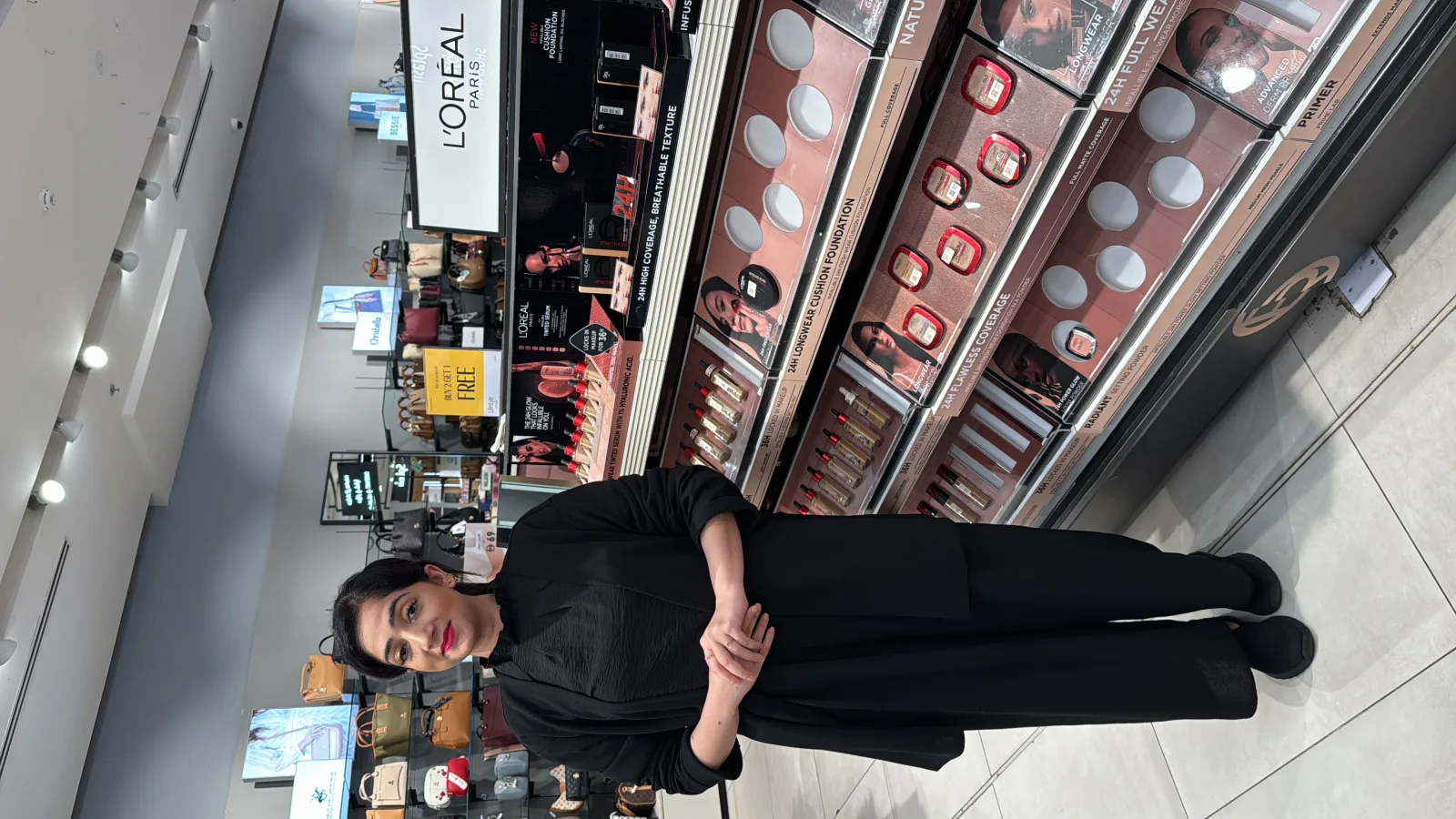 A beauty advisor beside the L'Oréal Paris display run in the cosmetics aisle.