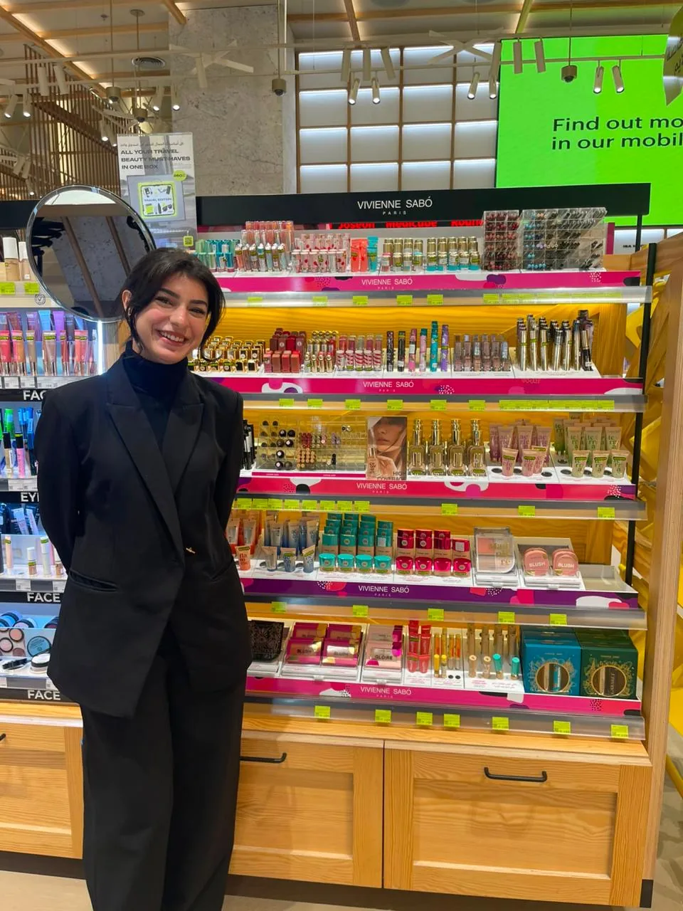 A beauty advisor beside the full Vivienne Sabo wall display.