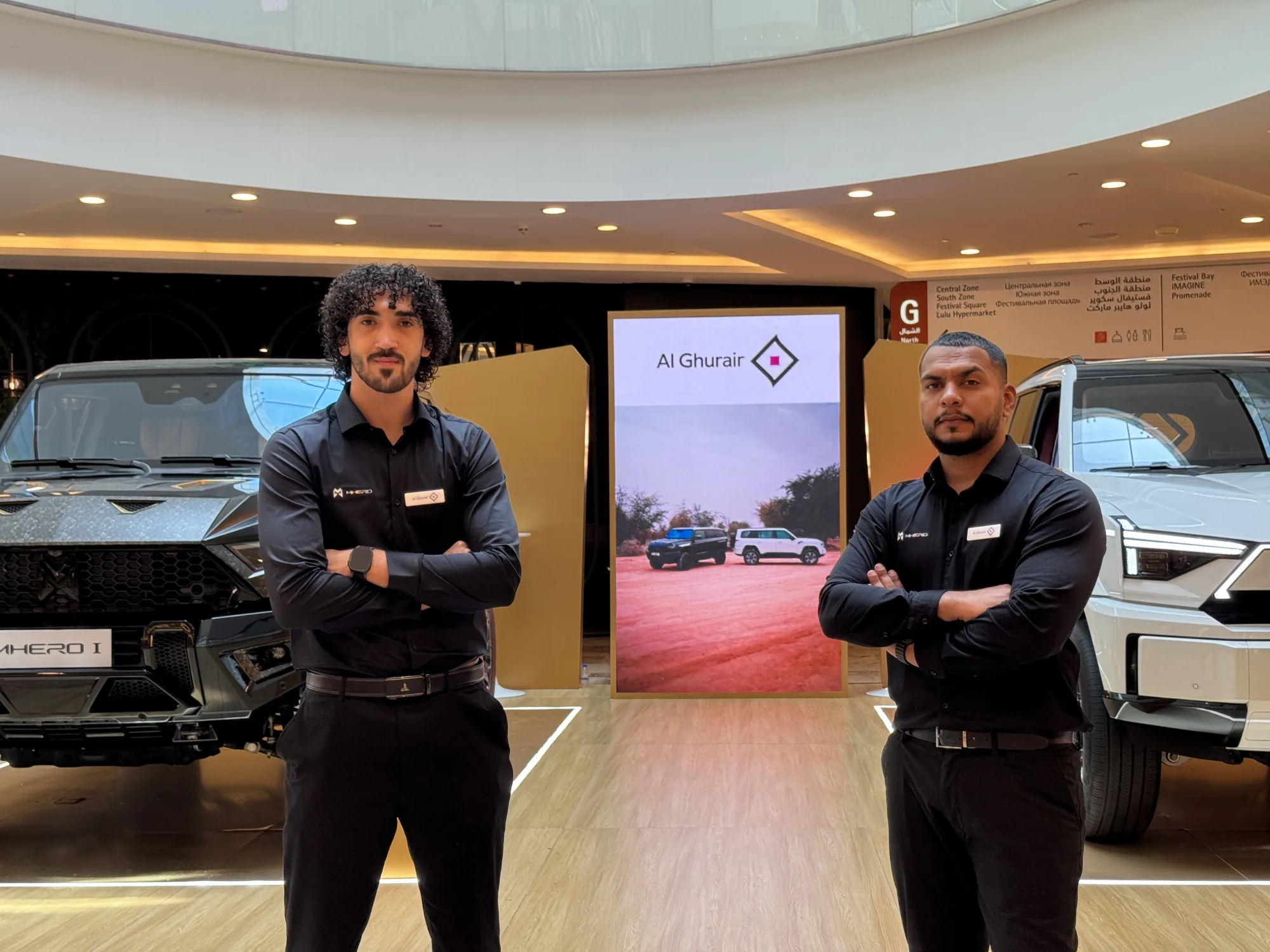 The two MHERO brand ambassadors in front of the MHERO I and MHERO II at the indoor stand.